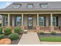 Close-up of the inviting front porch with stone pillars, shutters, and manicured landscaping at 406 Horizon Trl, Canton, GA 30114
