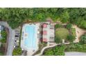 An aerial view shows a sparkling pool, manicured lawns, and a play area surrounded by lush greenery at 795 Hammond Dr # 503, Sandy Springs, GA 30328