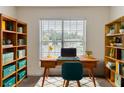 Well-lit home office with a wooden desk, bookshelves, and a comfortable workspace at 1006 Eagle Vw, Lawrenceville, GA 30044