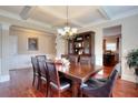 Dining room featuring hardwood floors, coffered ceiling, and stylish chandelier at 2458 Brook Park Trl, Snellville, GA 30078