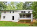 Back exterior of home with an enclosed porch overlooking a large backyard at 3530 Turner Heights Dr, Decatur, GA 30032