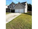 A view of the house showing the driveway, two car garage and well kept lawn at 7178 Glaspie Way, Atlanta, GA 30349