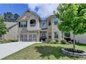 Charming two-story brick home featuring a well-maintained lawn and an attached two-car garage at 2410 Melton Common Dr, Dacula, GA 30019
