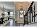 Grand foyer showcasing the entrance door, staircase with iron railings, and a view into the dining room at 2410 Melton Common Dr, Dacula, GA 30019