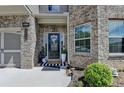 Close-up of a home's front entrance with a wreath on the door and plants flanking the entrance at 2410 Melton Common Dr, Dacula, GA 30019