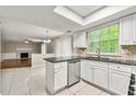 Bright kitchen with a skylight, white cabinets, tile backsplash and a view into the living room at 1386 Heritage Glen Dr, Marietta, GA 30068