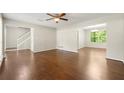 Spacious living room featuring hardwood floors, neutral walls, a ceiling fan and open archways to the dining area at 1386 Heritage Glen Dr, Marietta, GA 30068