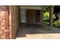 Carport with brick columns, a brown exterior door, and gray stained concrete at 6521 Menlo Way, Rex, GA 30273