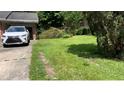 A view of the driveway, featuring green grass and a white Lexus at 6521 Menlo Way, Rex, GA 30273