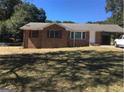 Charming brick home featuring a well-maintained lawn and a convenient carport at 6521 Menlo Way, Rex, GA 30273