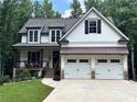 Beautifully landscaped craftsman-style home with a two-car garage and inviting covered porch at 104 Woodland Ln, Canton, GA 30114