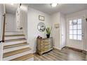 Inviting entryway with hardwood floors, staircase, and a decorative cabinet with a mirror at 151 Quail Hollow Dr, Dallas, GA 30157