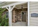 Inviting front porch with stone accents, craftsman-style details, and elegant lighting at 1637 Short Shadow Ln, Snellville, GA 30078