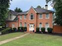 Classic two-story brick home featuring symmetrical windows and a well-manicured front lawn in a suburban setting at 200 Creek Run Ct, Alpharetta, GA 30005
