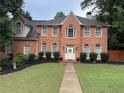 Charming brick home featuring a gabled roof, symmetrical windows, and a meticulously maintained front lawn at 200 Creek Run Ct, Alpharetta, GA 30005