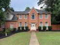 Inviting two-story brick home boasts symmetrical windows, a gabled roof, and a neatly landscaped front yard at 200 Creek Run Ct, Alpharetta, GA 30005