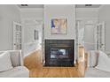 Living room featuring a fireplace with elegant French doors leading to other areas of the home at 200 Creek Run Ct, Alpharetta, GA 30005