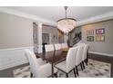 Bright dining room with a decorative light fixture, hardwood floors, and seating for eight at 2720 Garonne Way, Cumming, GA 30041
