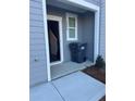 Close-up of front door and address of a light gray townhome with a gray trash can at 2554 Coventry Sw St, Atlanta, GA 30331