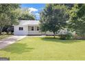 This home features a well-kept front yard with lush green grass and mature trees at 33 Russell Rd, Mcdonough, GA 30252