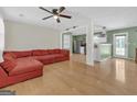 Open-concept living space with hardwood floors, a spacious red sectional, and modern lighting at 33 Russell Rd, Mcdonough, GA 30252