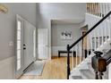 Bright foyer featuring hardwood floors, a staircase with wooden banister and neutral paint at 3845 Lake Lanier Dr, Duluth, GA 30097