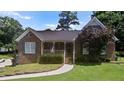 Classic brick home with a covered porch, manicured lawn, and charming curb appeal at 3500 Thunderwood Ln, Snellville, GA 30039