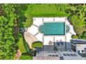 Aerial view of a rectangular pool with a spa, surrounded by a stone patio, grass, and mature trees at 4356 N Buckhead Ne Dr, Atlanta, GA 30342
