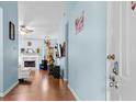 Welcoming entryway with light blue walls and hardwood floors leading to a sunlit living area with a fireplace at 580 Lilburn School Rd, Lilburn, GA 30047