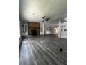 Spacious living room with beautiful floors, a ceiling fan, and a stone fireplace at 6830 Pawnee Trl Se, Acworth, GA 30102