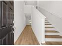 Bright foyer featuring wood-look flooring, staircase, and neutral paint palette at 2472 Cotton Ln, Douglasville, GA 30135