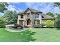 Stately residence showcasing lush greenery, stone details, and a curved walkway leading to the front entrance at 2910 Creek Tree Ln, Cumming, GA 30041