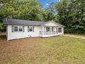 Recently renovated ranch-style home featuring a freshly painted white brick facade, covered porch, and mature trees at 8535 Hiram Acworth Hwy, Dallas, GA 30157