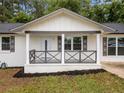 Inviting covered front porch with decorative railing accents the freshly painted white brick exterior at 8535 Hiram Acworth Hwy, Dallas, GA 30157