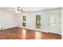 Airy living room featuring wood floors, a ceiling fan, and a front entry door at 240 Wellington Dr, Mcdonough, GA 30252