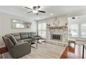 Spacious living room featuring cherrywood floors, a stone fireplace, and windows with plantation shutters at 3210 Lake Pointe Cir, Roswell, GA 30075