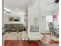 Bright living room featuring cherrywood floors, stone fireplace, stylish furniture, and large windows with plantation shutters at 3210 Lake Pointe Cir, Roswell, GA 30075