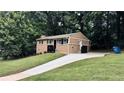 A charming home with a long driveway, lush green lawn, and mature trees providing a serene and private setting at 2443 Abner Nw Pl, Atlanta, GA 30318