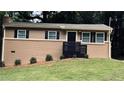 Close-up of a freshly painted brick home with black shutters and a modern black railing by the front door at 2443 Abner Nw Pl, Atlanta, GA 30318
