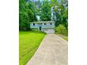 Home with a driveway, manicured lawn, and mature trees at 3544 Citrus Dr, Duluth, GA 30096
