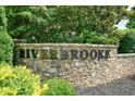 Stone community entrance sign with the 'Riverbrooke' name in metal lettering at 1630 Eaglerock Dr, Suwanee, GA 30024
