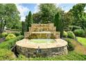 Multi-tiered stone water feature surrounded by manicured landscaping at 1630 Eaglerock Dr, Suwanee, GA 30024