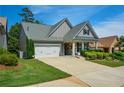 View of the well-maintained home featuring a two-car garage, a lush front yard, and stone accents at 505 Appalachian Woods Dr, Canton, GA 30114