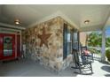 Inviting front porch with stone accents, rocking chairs, and a bright red front door at 505 Appalachian Woods Dr, Canton, GA 30114