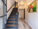 Inviting foyer with hardwood floors, elegant lighting, black staircase, and unique artwork for a stylish entrance at 6426 Queens Court Trce # 7, Mableton, GA 30126