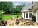 Inviting flagstone patio with outdoor seating overlooking a beautifully landscaped yard and mature trees at 1000 Collingtree Ct, Mcdonough, GA 30253