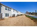 The back of several townhomes, showcasing yards and white picket fences against a clear blue sky at 2873 Snapfinger Mnr, Decatur, GA 30035