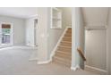Neutral hallway featuring carpeted stairs, a coat closet and access to the home's exterior at 11302 Musette Cir, Alpharetta, GA 30009