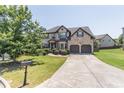 Charming two-story brick home with a well-manicured lawn, driveway, and inviting curb appeal at 2183 Trinity Grove Ct, Dacula, GA 30019