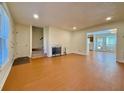 Bright living room featuring wood-look flooring, a fireplace, and access to other rooms at 3533 Mulberry Way, Duluth, GA 30096